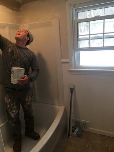 A Braendel Services team member works on installing a tub and shower in Erie, PA.