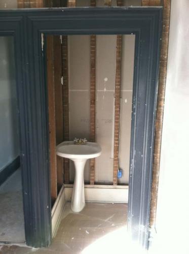 A look at a residential bathroom after Braendel has stripped out everything to make space for new walls and fixtures.