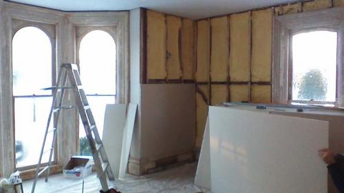 A shot of a room with bay windows. Drywall is ready to be hung!