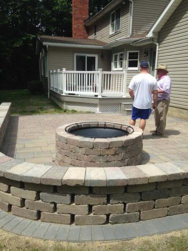 Beige stone match and accentuate the siding of this home and the firepit in the backyard.