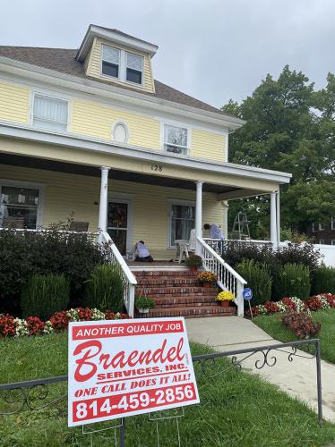 Yellow siding and white trimwork give this multistory home a stately appearance